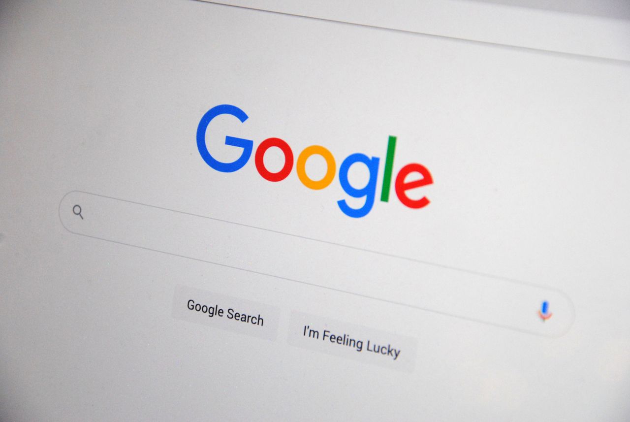 home-services-01 Close-up of the Google homepage on a screen showing search options.